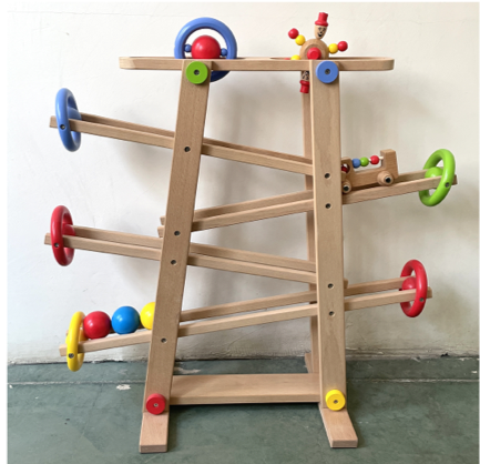 Rampe de billes Montessori en bois avec boules colorées dévalant la pente